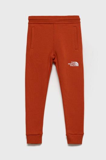 Detské bavlnené nohavice The North Face oranžová farba, s nášivkou