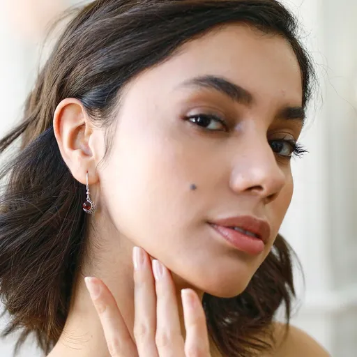 Zahnuté strieborné náušnice s jantárovým očkom